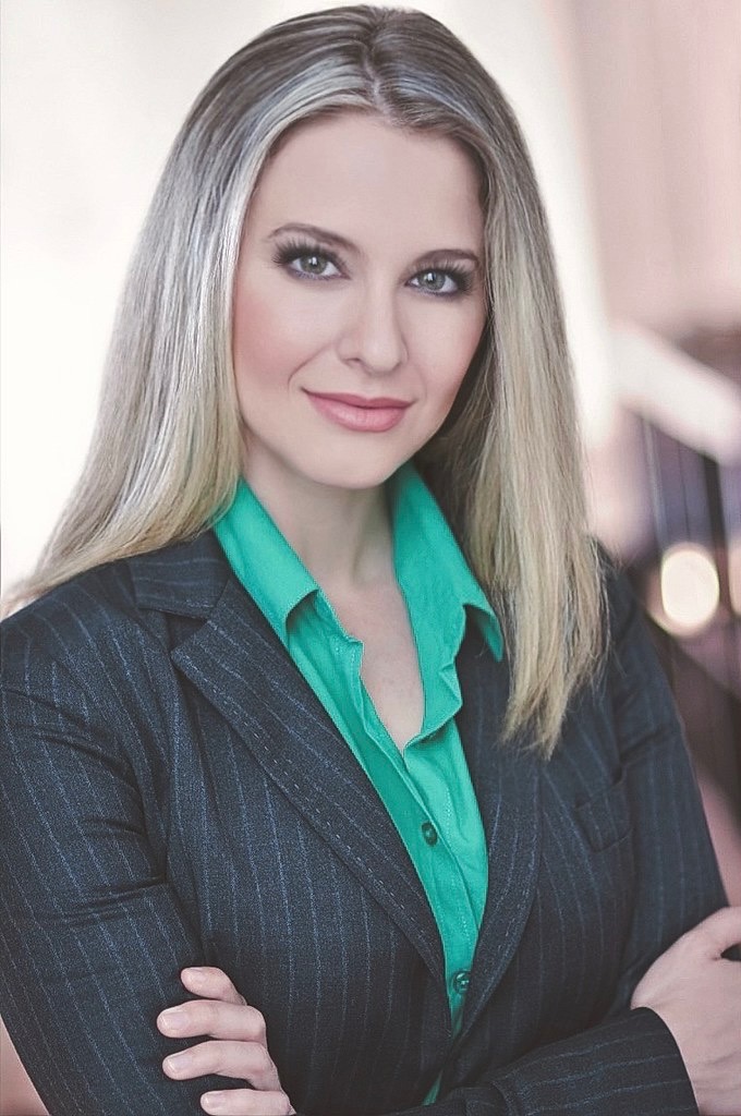 Professional headshot in a pinstripe blazer and green blouse