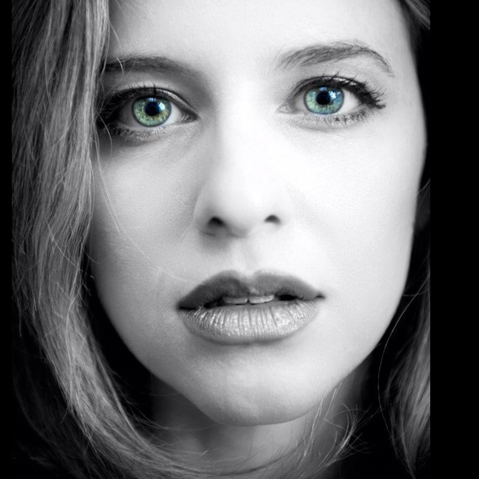 Black and white close-up with color-isolated blue-green eyes