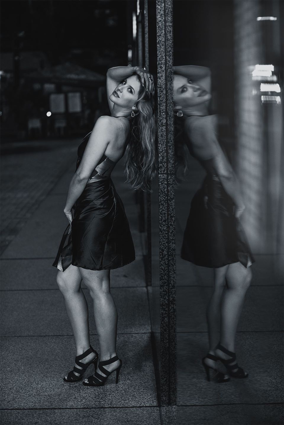 Black and white night portrait reflected in a city window