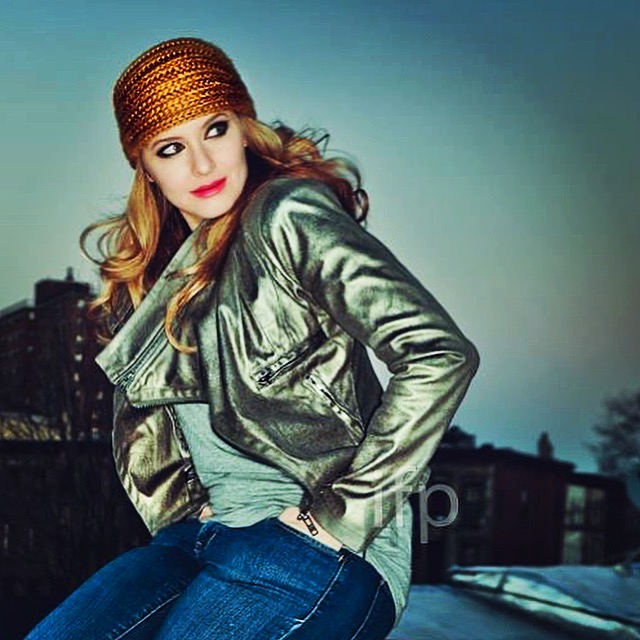 Rooftop portrait at dusk in a gold headwrap and silver jacket