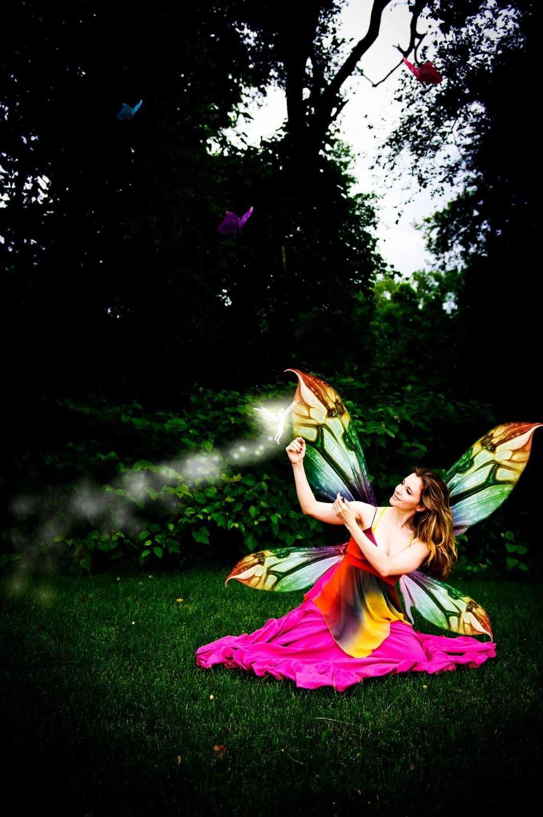 Jenilyn in fairy wings on a lawn at dusk