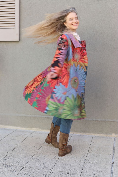 Mid-twirl in a floral coat on a city sidewalk